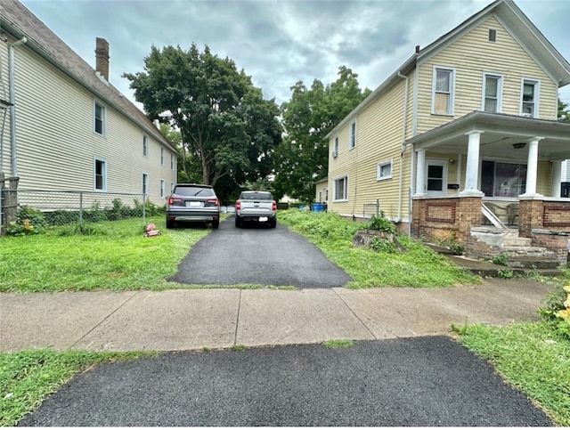 view of property exterior with a yard and covered porch