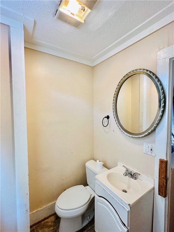 bathroom featuring vanity, a textured ceiling, and toilet