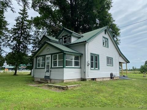 rear view of property featuring a lawn