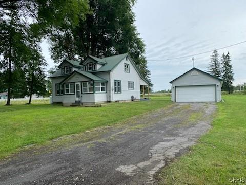 view of front of property with an outdoor structure, a garage, and a front yard