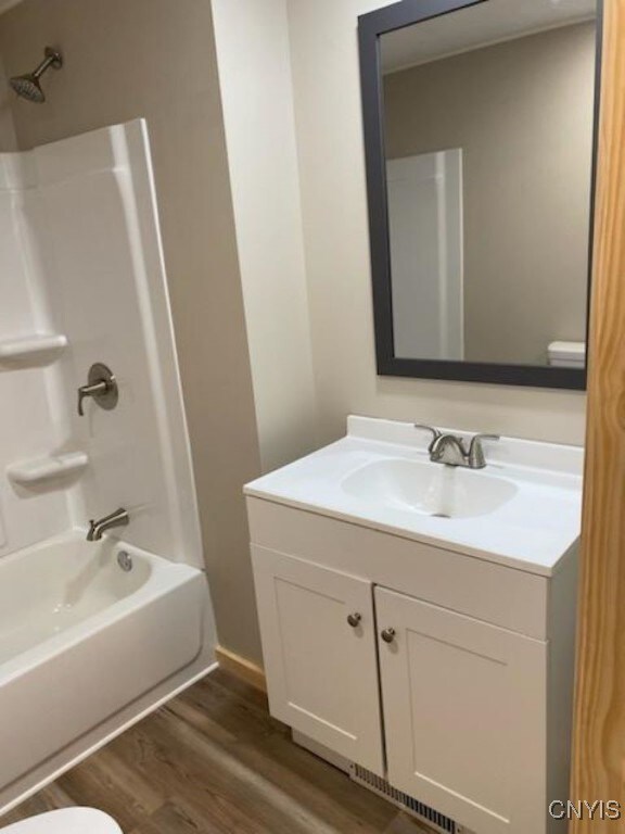 full bathroom featuring vanity, shower / washtub combination, toilet, and hardwood / wood-style floors