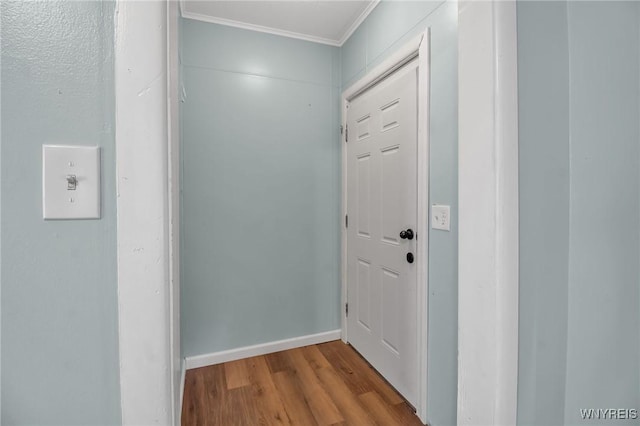 doorway to outside featuring crown molding, wood finished floors, and baseboards