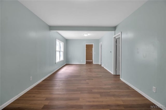 empty room with dark wood finished floors and baseboards