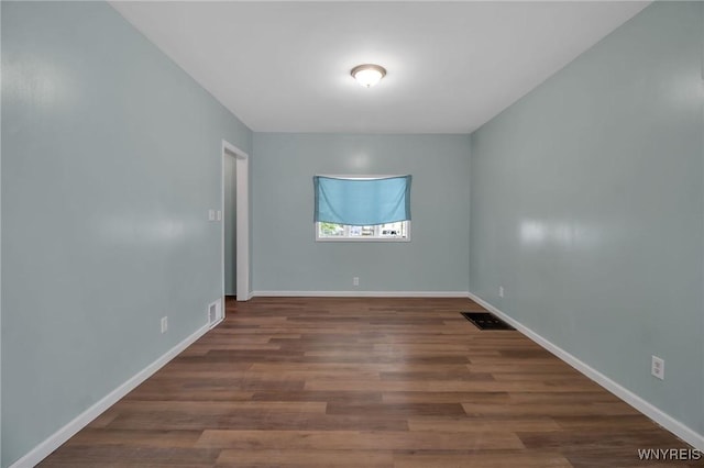 spare room featuring visible vents, baseboards, and wood finished floors