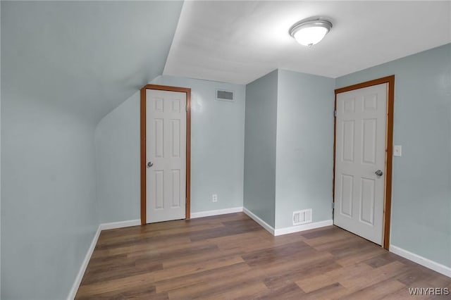 bonus room with visible vents, baseboards, wood finished floors, and vaulted ceiling