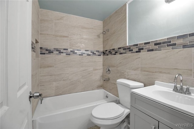 full bathroom featuring toilet, tile walls, bathtub / shower combination, and vanity