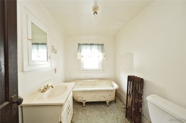 bathroom featuring radiator heating unit, a tub, vanity, and toilet