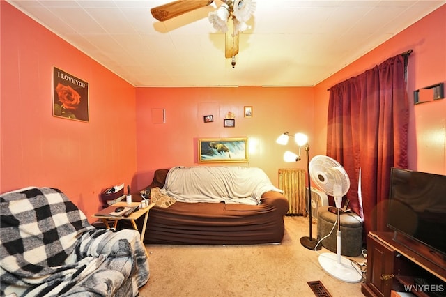 carpeted bedroom featuring ceiling fan and radiator heating unit