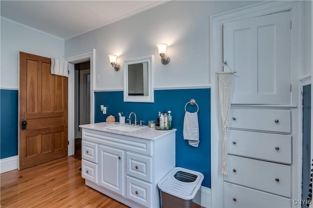 bathroom with vanity, hardwood / wood-style floors, and ornamental molding