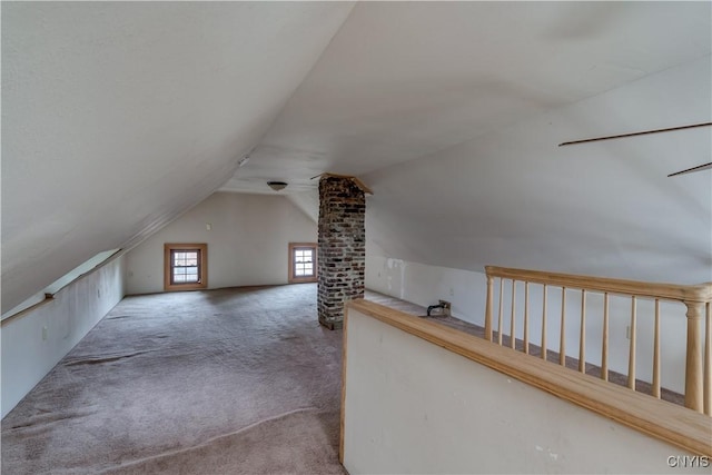 additional living space featuring lofted ceiling and carpet floors