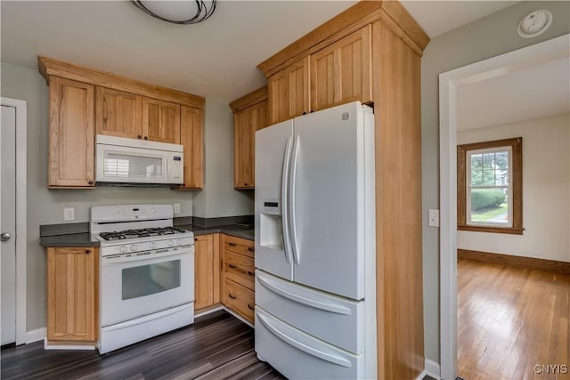 kitchen with dark hardwood / wood-style flooring and white appliances