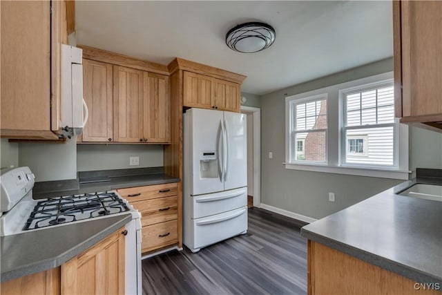 kitchen with white appliances, dark hardwood / wood-style floors, and sink