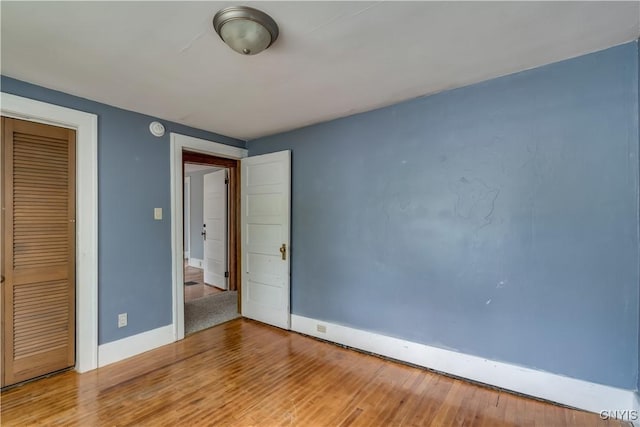 unfurnished bedroom featuring hardwood / wood-style floors and a closet