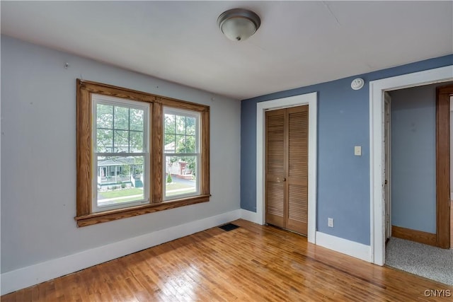 unfurnished bedroom featuring a closet and light hardwood / wood-style flooring