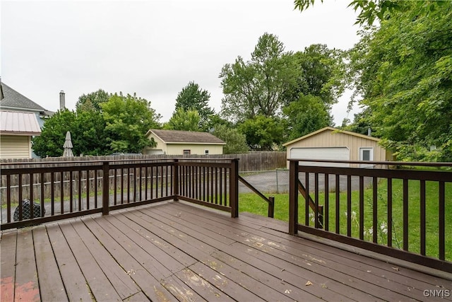 wooden deck featuring an outbuilding, a garage, and a lawn