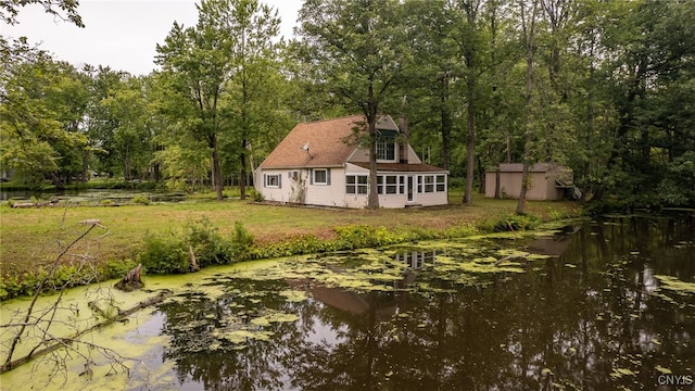 back of house with a yard and a storage unit