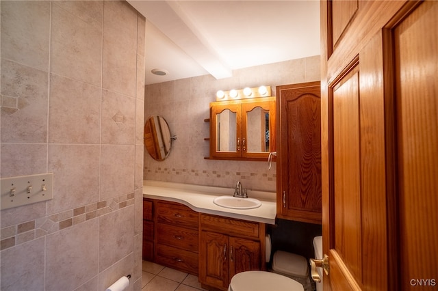 bathroom featuring beam ceiling, toilet, vanity, tile walls, and tile patterned floors