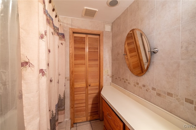 bathroom featuring vanity, tile patterned flooring, and tile walls