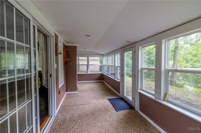 unfurnished sunroom featuring vaulted ceiling and a wealth of natural light