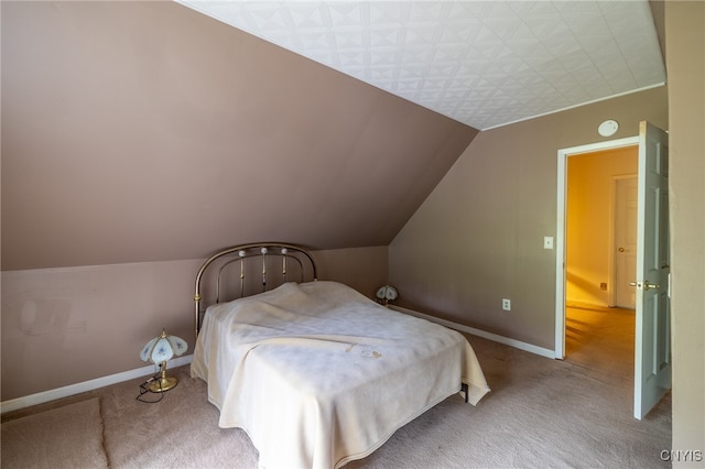 bedroom with carpet floors and lofted ceiling