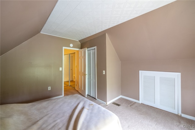 unfurnished bedroom featuring light carpet and lofted ceiling