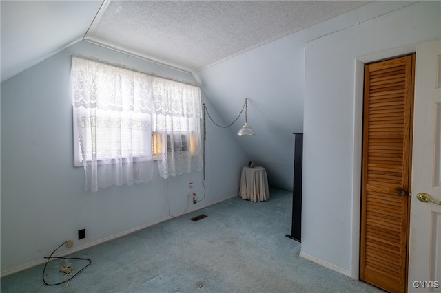 bonus room featuring vaulted ceiling, carpet, and a textured ceiling