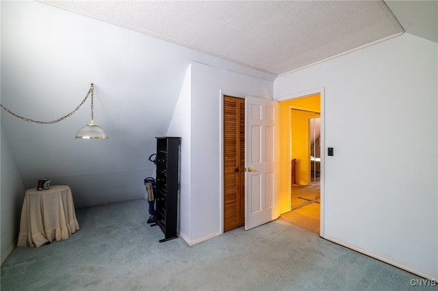 interior space featuring a textured ceiling, carpet floors, and lofted ceiling