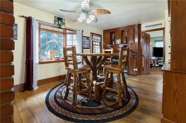 dining space with ceiling fan and light hardwood / wood-style flooring