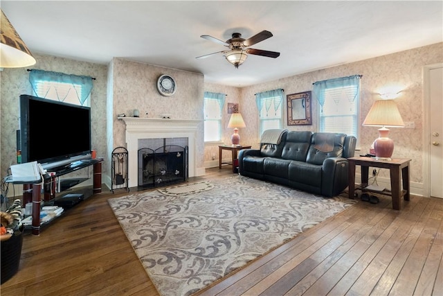 living room featuring ceiling fan, a fireplace, and hardwood / wood-style flooring