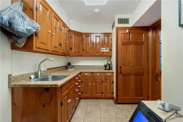 kitchen featuring light tile patterned floors and sink