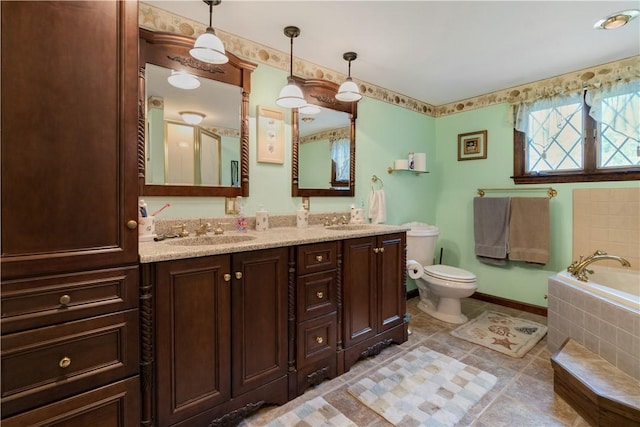 bathroom with toilet, tiled tub, dual vanity, and tile patterned floors