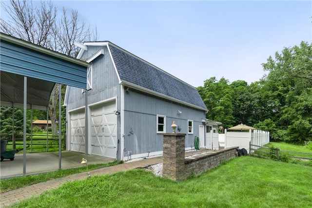 view of home's exterior with a lawn, a garage, and an outdoor structure