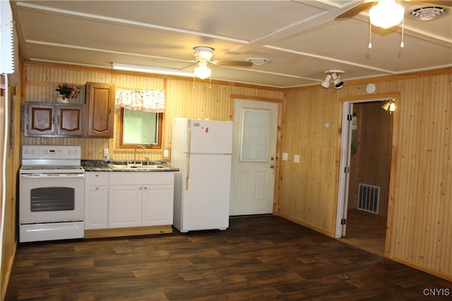 kitchen with ceiling fan, dark wood-type flooring, wood walls, white appliances, and sink