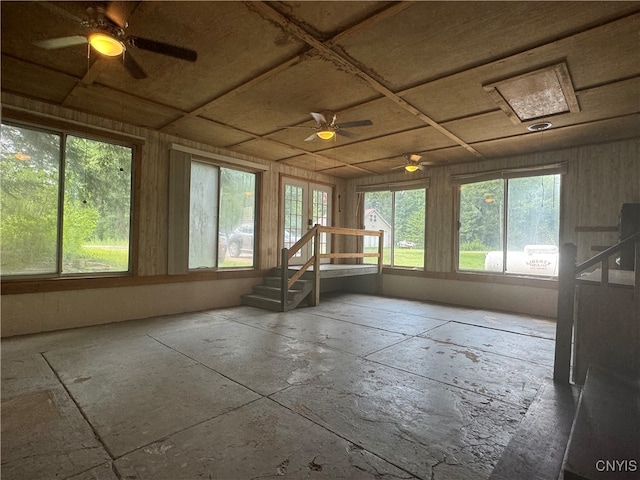 unfurnished sunroom featuring ceiling fan