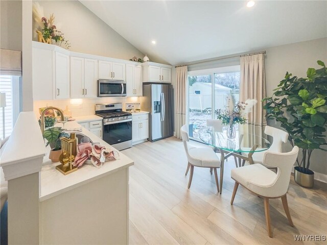 kitchen featuring stainless steel appliances, a healthy amount of sunlight, light countertops, and white cabinets