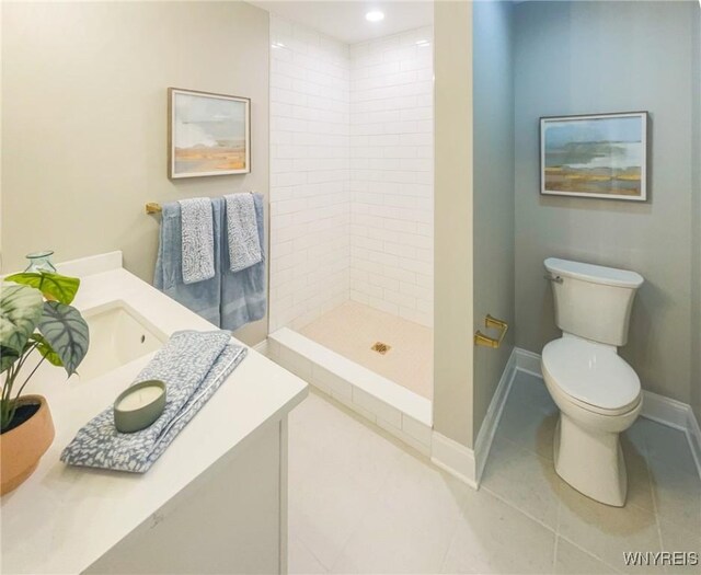 bathroom with toilet, tile patterned floors, tiled shower, and vanity