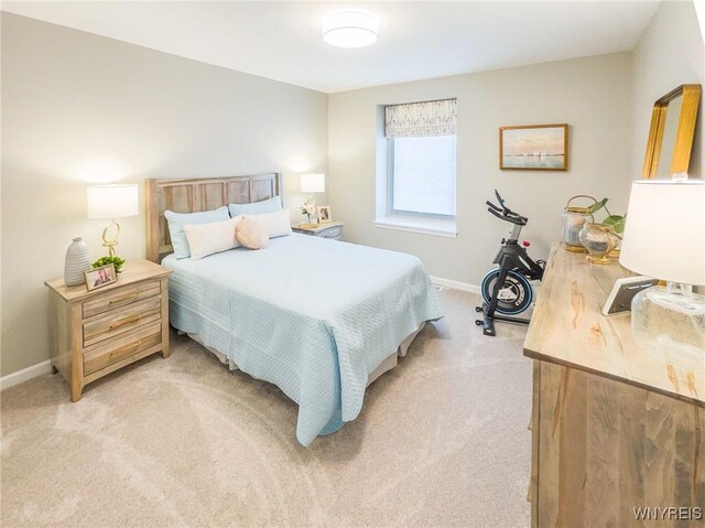 bedroom with light carpet and baseboards