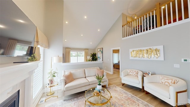 living room featuring hardwood / wood-style floors, high vaulted ceiling, and a premium fireplace