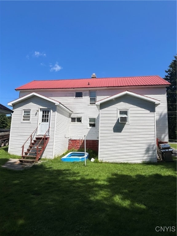 rear view of property featuring a yard