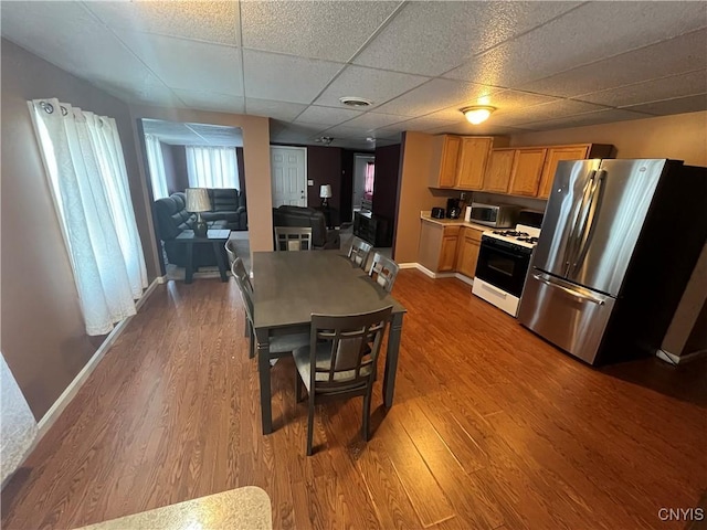 kitchen featuring visible vents, wood finished floors, freestanding refrigerator, gas range oven, and light countertops