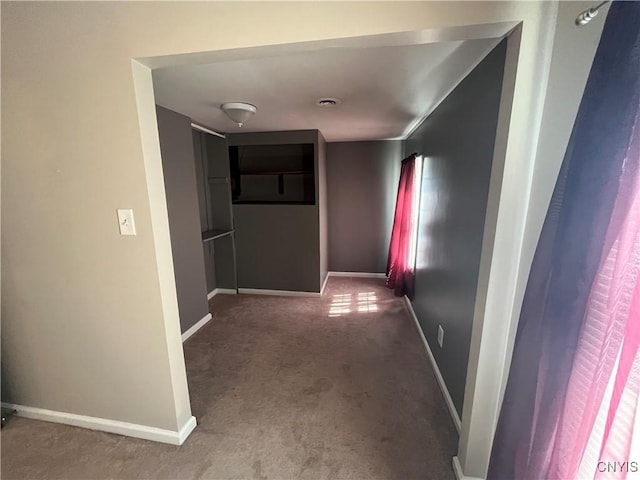 corridor with carpet and baseboards