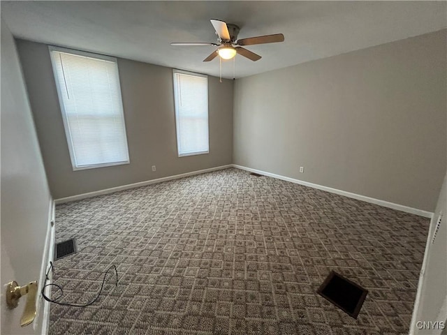 unfurnished room with a ceiling fan, carpet, visible vents, and baseboards