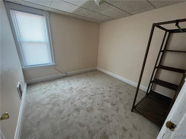 interior space with a drop ceiling and light carpet