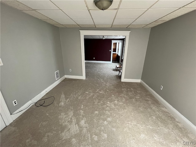 carpeted spare room featuring a paneled ceiling