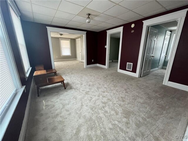 empty room with light carpet and a paneled ceiling