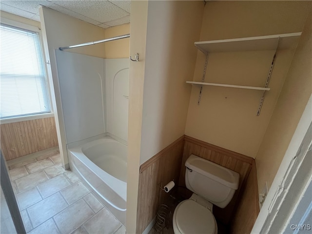 bathroom featuring shower / bathtub combination, tile patterned floors, toilet, and plenty of natural light