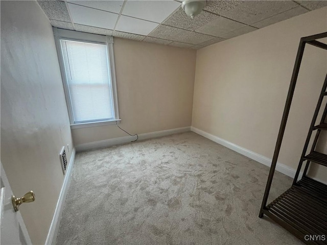 unfurnished bedroom with light carpet, visible vents, baseboards, and a paneled ceiling