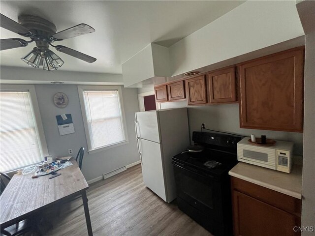 kitchen with ceiling fan, a baseboard heating unit, white appliances, and light hardwood / wood-style floors