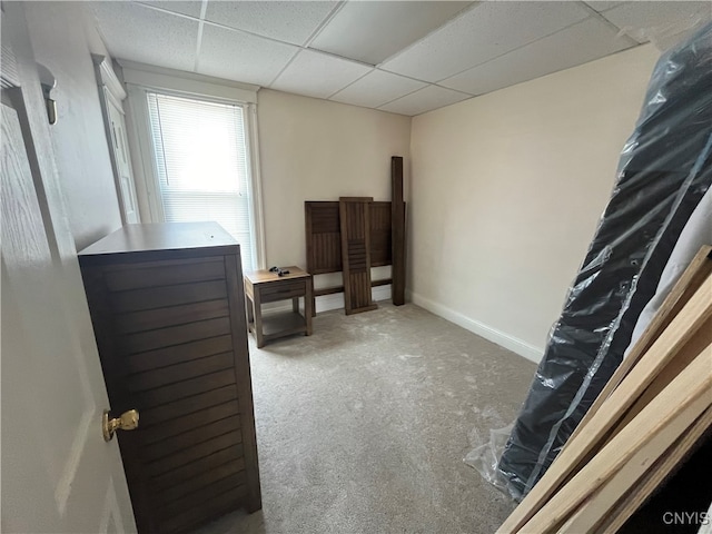 carpeted bedroom featuring a drop ceiling