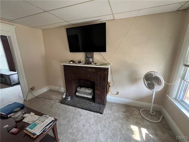 living area with a paneled ceiling, a brick fireplace, light carpet, and baseboards